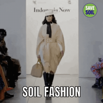 A Model Walks Down A Runway At A Fashion Show With The Words Soil Fashion Behind Her GIF