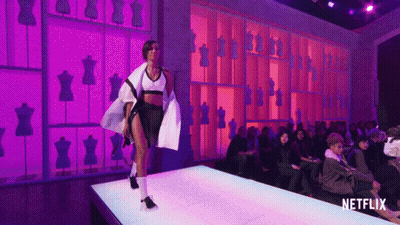 A Model Walks Down A Runway With A Netflix Logo In The Corner GIF