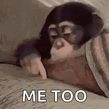 A Monkey Is Laying On A Bed And Pointing At Something . GIF