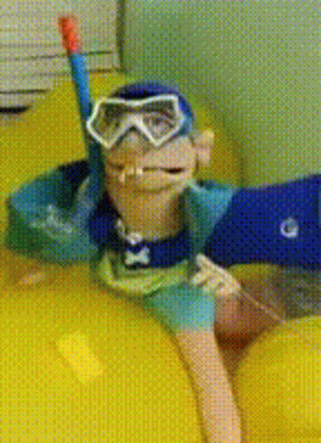 A Monkey Wearing Goggles And A Snorkel Is Floating On A Yellow Raft GIF