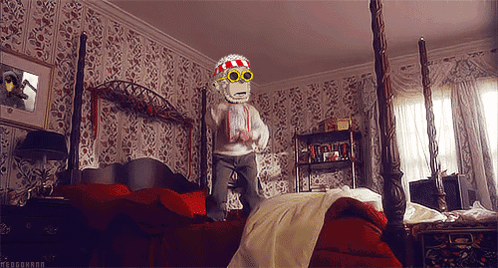 A Monkey Wearing Sunglasses And A Scarf Is Jumping On A Bed In A Bedroom GIF