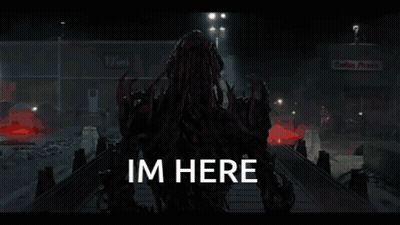 A Monster Is Standing In A Dark Room With The Words Im Here Written On The Bottom . GIF