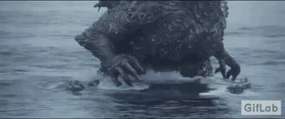 A Monster Is Swimming In The Ocean With A Remote Control In Its Mouth . GIF