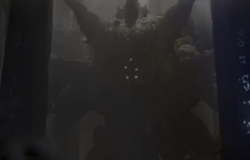 A Monster With Horns Is Standing In A Dark Forest GIF