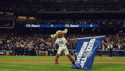 A Moose Mascot Is Holding A Blue Seize The Moment Flag GIF
