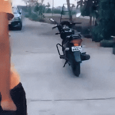A Motorcycle Is Parked On The Side Of The Road And Has A License Plate That Says Bb67 GIF