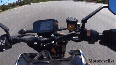 A Motorcyclist Is Riding A Ktm Motorcycle Down The Road GIF