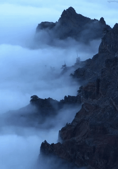 A Mountain Covered In Clouds With The Word Greeting Visible In The Corner GIF