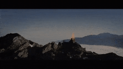 A Mountain Covered In Snow With A Few Clouds In The Sky GIF