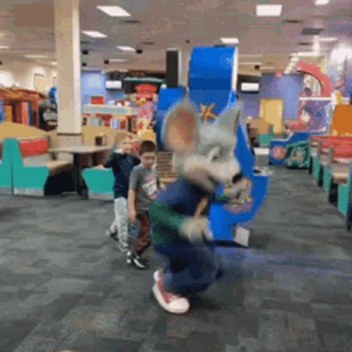 A Mouse Mascot Is Dancing In A Chuck E Cheese Restaurant With Children . GIF