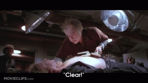 A Movie Clip From Movieclips.com Shows A Man Laying On The Floor Being Examined By A Doctor GIF
