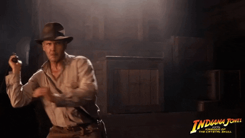 A Movie Poster For Indiana Jones Shows A Man In A Hat Holding A Gun GIF