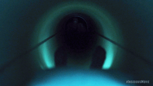 A Movie Poster For The Insidious Movie Shows A Man In A Hospital Gown Crawling Through A Tunnel GIF