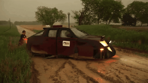 A Muddy Road With A Car That Has A Sticker On It That Says ' Texas ' GIF