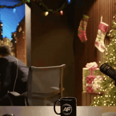 A Mug With The Letter Af On It Sits On A Table In Front Of A Christmas Tree GIF