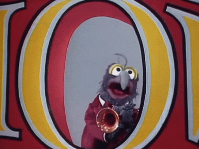 A Muppet Is Playing A Trumpet In Front Of A Sign That Says Loot GIF
