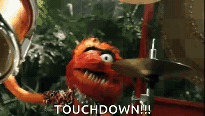 A Muppet Is Playing Drums And Says Touchdown . GIF