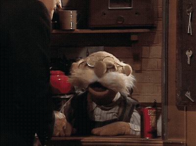 A Muppet Is Sitting At A Table With A Can Of Popeye 'S GIF