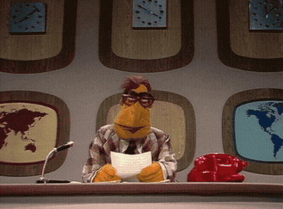 A Muppet Sitting At A Desk With A Piece Of Paper In Front Of Him GIF