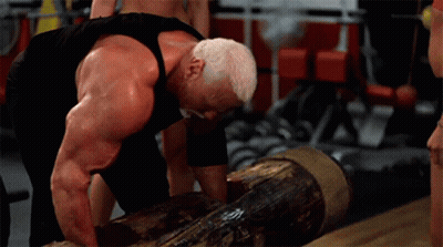 A Muscular Man Is Lifting A Log In A Gym . GIF