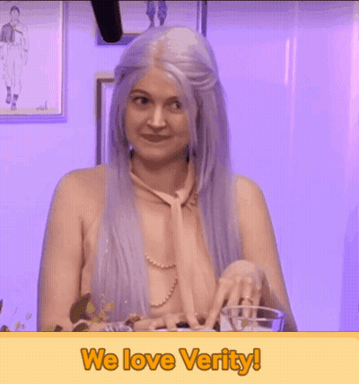A Naked Woman With Purple Hair Is Holding A Glass With The Words We Love Verity Below Her GIF