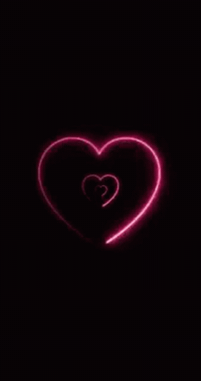 A Neon Heart Is Glowing In The Dark On A Black Background GIF