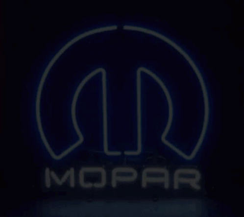 A Neon Sign For Mopar Is Lit Up In The Dark GIF