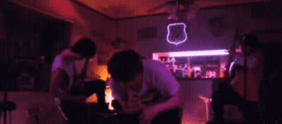 A Neon Sign For Route 66 Hangs From The Ceiling In A Dark Room GIF