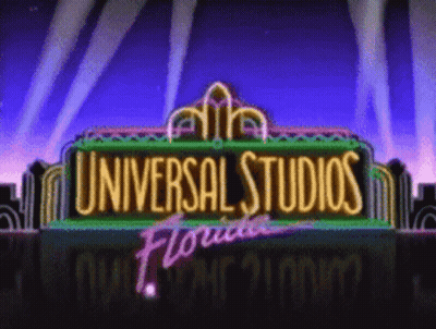 A Neon Sign For Universal Studios Florida With A City In The Background GIF