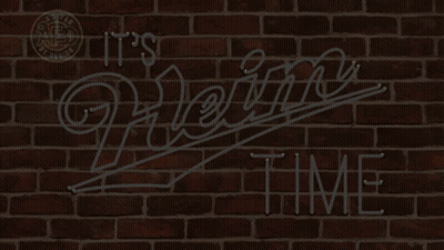 A Neon Sign That Says " It 'S Heinz Time " On A Brick Wall GIF