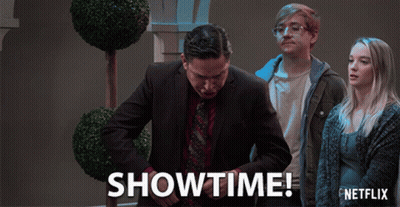 A Netflix Ad Shows A Man In A Suit And Tie Standing Next To A Woman GIF