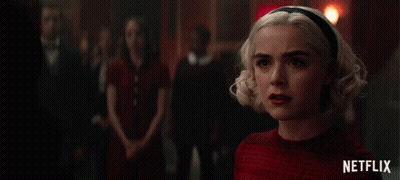 A Netflix Ad Shows A Woman In A Red Sweater GIF