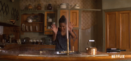 A Netflix Ad Shows A Woman Washing Dishes In A Kitchen GIF