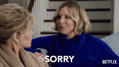 A Netflix Ad Shows Two Women Sitting On A Couch And One Says Sorry GIF