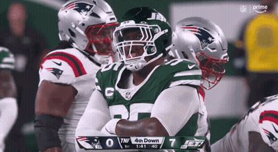 A New York Jets Football Player Stands With His Arms Crossed GIF