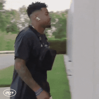 A New York Jets Player Is Walking Down A Street GIF