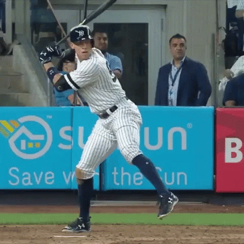 A New York Yankees Player Swings His Bat At A Pitch GIF