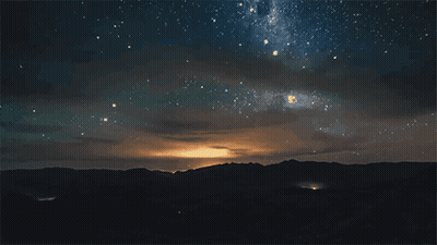 A Night Sky Filled With Lots Of Stars And Clouds GIF