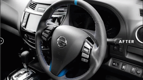 A Nissan Steering Wheel With A Blue Stitching Is Shown GIF