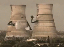 A Nuclear Power Plant Is Being Demolished With Smoke Coming Out Of It . GIF