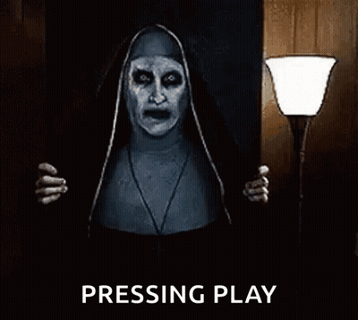 A Nun From The Movie The Conjuring Is Standing In A Dark Room Holding A Lamp And Screaming . GIF