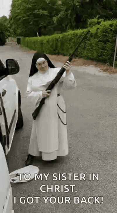A Nun Is Holding A Gun In Front Of A Car And Says `` To My Sister In Christ , I Got Your Back ! '' GIF