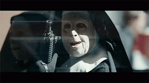 A Nun Is Holding A Gun In Her Hand And Looking Out Of A Car Window . GIF