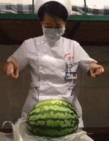 A Nurse In A White Uniform Is Cutting A Watermelon GIF