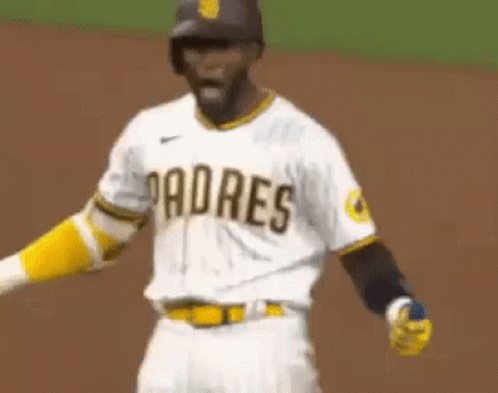 A Padres Baseball Player Is Standing On The Field With His Arms Outstretched And His Mouth Open . GIF