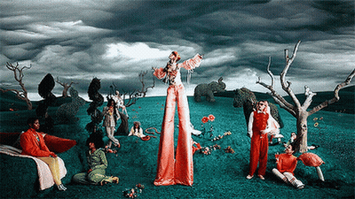 A Painting Of A Group Of People In A Field With A Woman On Stilts GIF