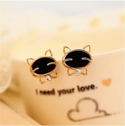 A Pair Of Cat Shaped Earrings With Black And Clear Stones GIF