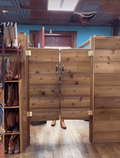 A Pair Of Cowboy Boots Are Hanging On A Shelf Next To A Wooden Door GIF