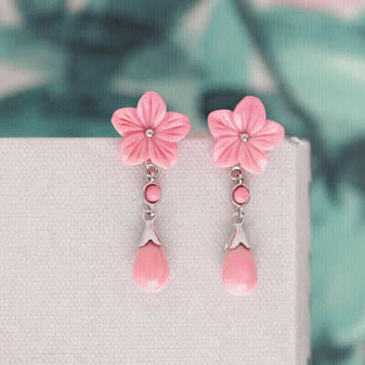 A Pair Of Earrings With Pink Flowers And Pink Drops GIF