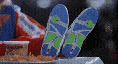 A Pair Of Flip Flops Are Laying On A Table Next To A Bag Of French Fries GIF